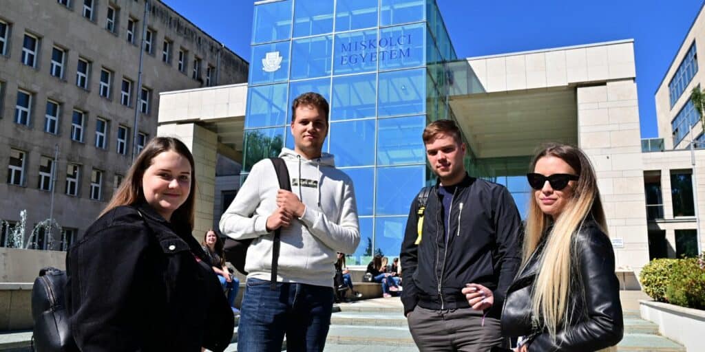 Miskolci Egyetem előtt hallgatók állnak.