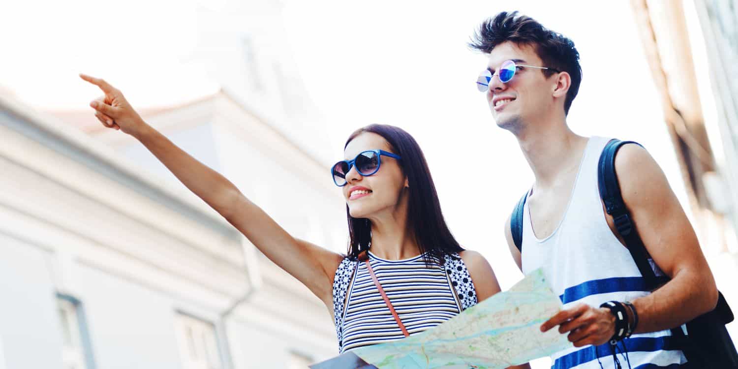 Fiatalok térképet olvasnak és vidáman turistáskodnak.